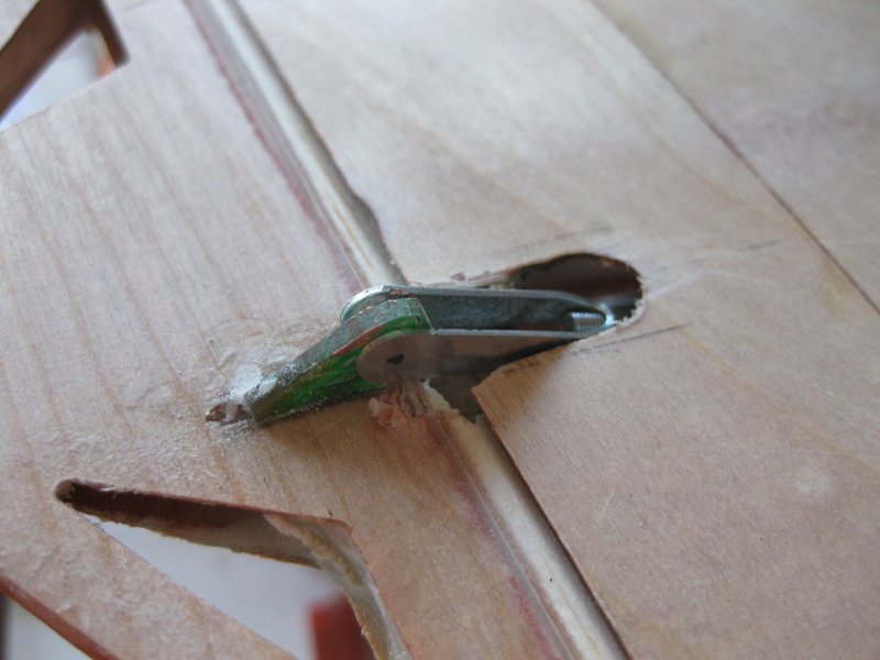 von oben sieht man hier am Ruderhorn die Balsa-Dichtlippe die in eine U-förmige Hohlkehle hineinläft. Ich bau das bei Rippenflächen schon seit 15 Jahren so. Von unten ein einfaches, aerodynamisch einwandfreies Tesascharnier, von oben siehts aber aus wie die Hohlkehle des Originals.