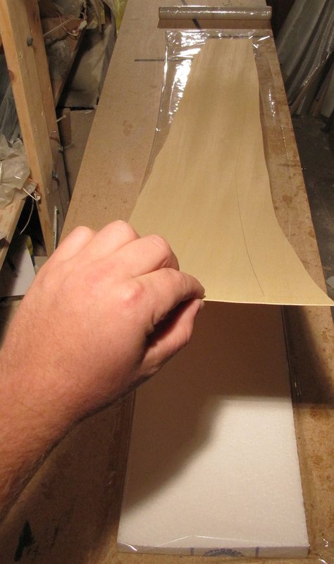 Oberschale auf die Pressplatte gelegt, mit Frischhaltefolie abgedeckt und das Abachi grob mit Übermaß zugeschnitten