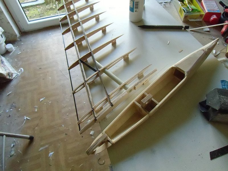 ....und so rum kommt der Rumpf nachher an den Flügel. Man sieht wie die Pylone nachher in Aussparungen der Wurzelrippen eingtreifen. Hinten kommt der Steckungsstab durch, vorne die Torsionsstifte. Zum montieren des Flügels werden nur die Flächen aufgeschoben und mit einem Tesastreifen oder Multilock gesichert. Bei seitlicher Belastung stützt sich die zweite Flügelrippe auf der Rumpfseitenwand ab.