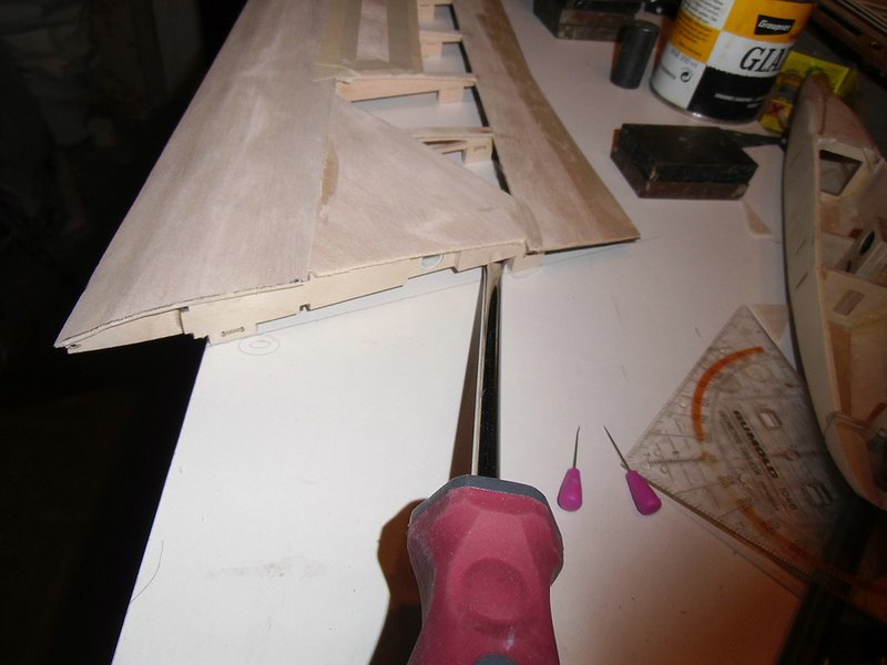 Beim abnehmen des Flügels vom Baubrett werden die Sperrholzrippen mit einem Schraubenzieher oder Stechbeitel abgehebelt. Die Füße der Balsarippen brechen schon dabei meist an den Sollbruchstellen, die hartnäckigeren werden mit dem Cutter abgeschnitten