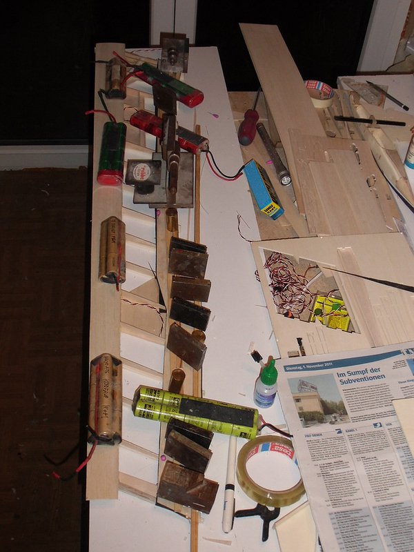 Untere Endleistenbeplankung rechts. Die Leisten und Gewichte pressen die Endleiste in die Helling, damit sollte die Oberseitenkontur der Endleiste genau stimmen und scharf ausgeschliffen wird nur von der Unterseite.